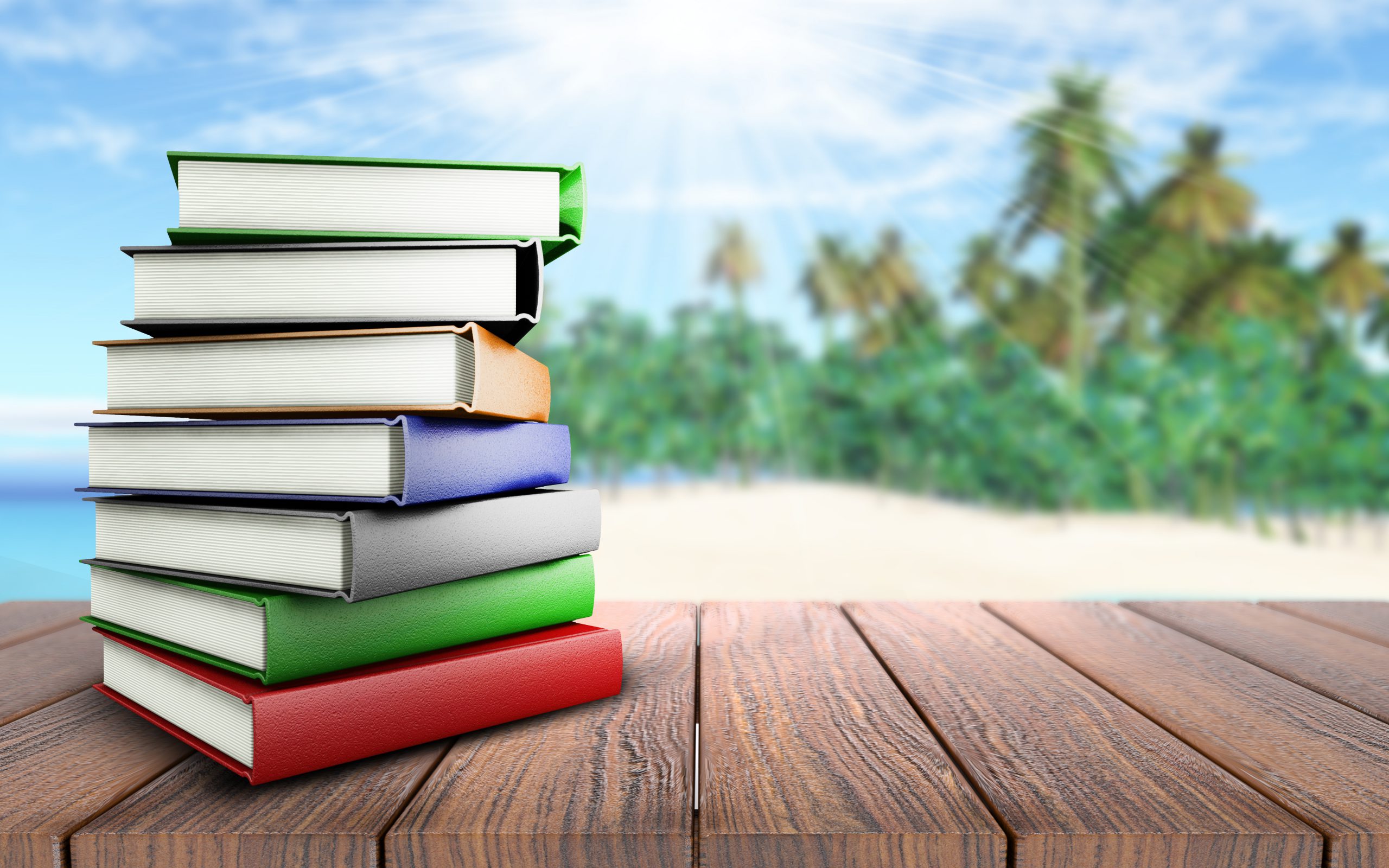 3D books on wooden table looking out to palm tree beach